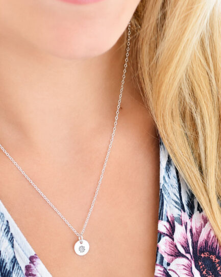 woman waring silver birth flower necklace